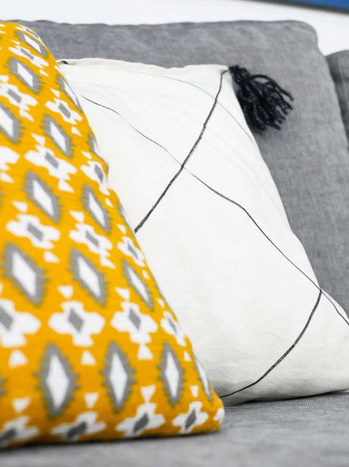 gros plan en premier plan coussin jaune et arrière blanc en arrière plan