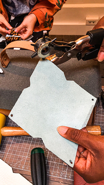 Fille tenant un patron porte monnaie cuir bleu au DIY festival